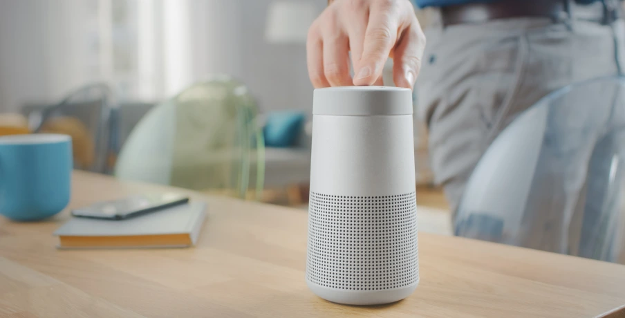 A person pressing a button of a portable speaker